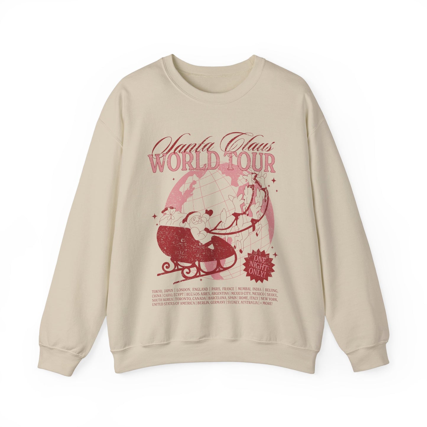A beige crewneck sweatshirt with a graphic print of a red sleigh on the front, text reading 'Santa Claus World Tour', and distressed design elements.