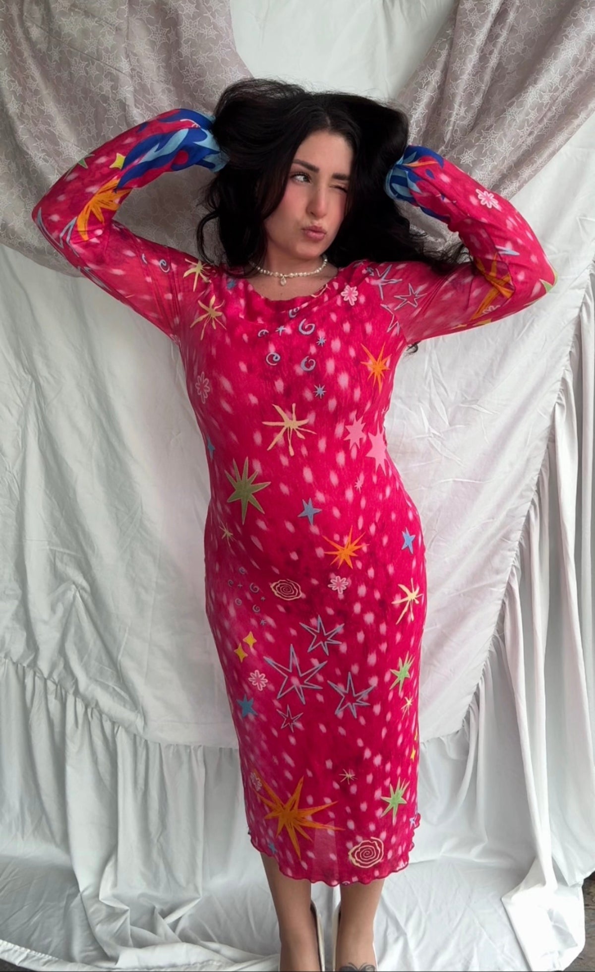 LOVE WORLD’s Deer Stars hot pink mesh midi dress with multicolored stars, spirals, and blue flame accents on long sleeves