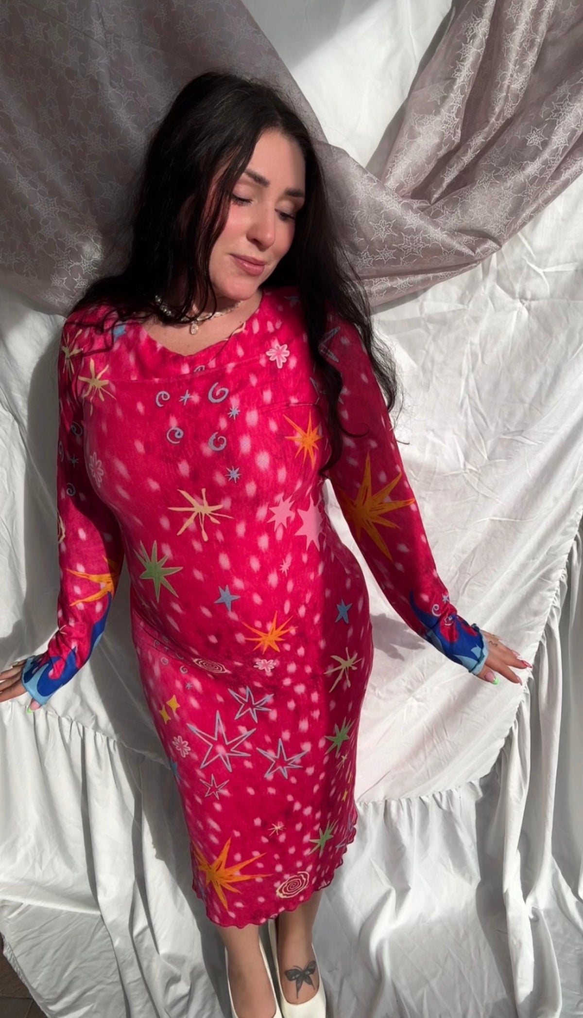 LOVE WORLD’s Deer Stars hot pink mesh midi dress with multicolored stars, spirals, and blue flame accents on long sleeves