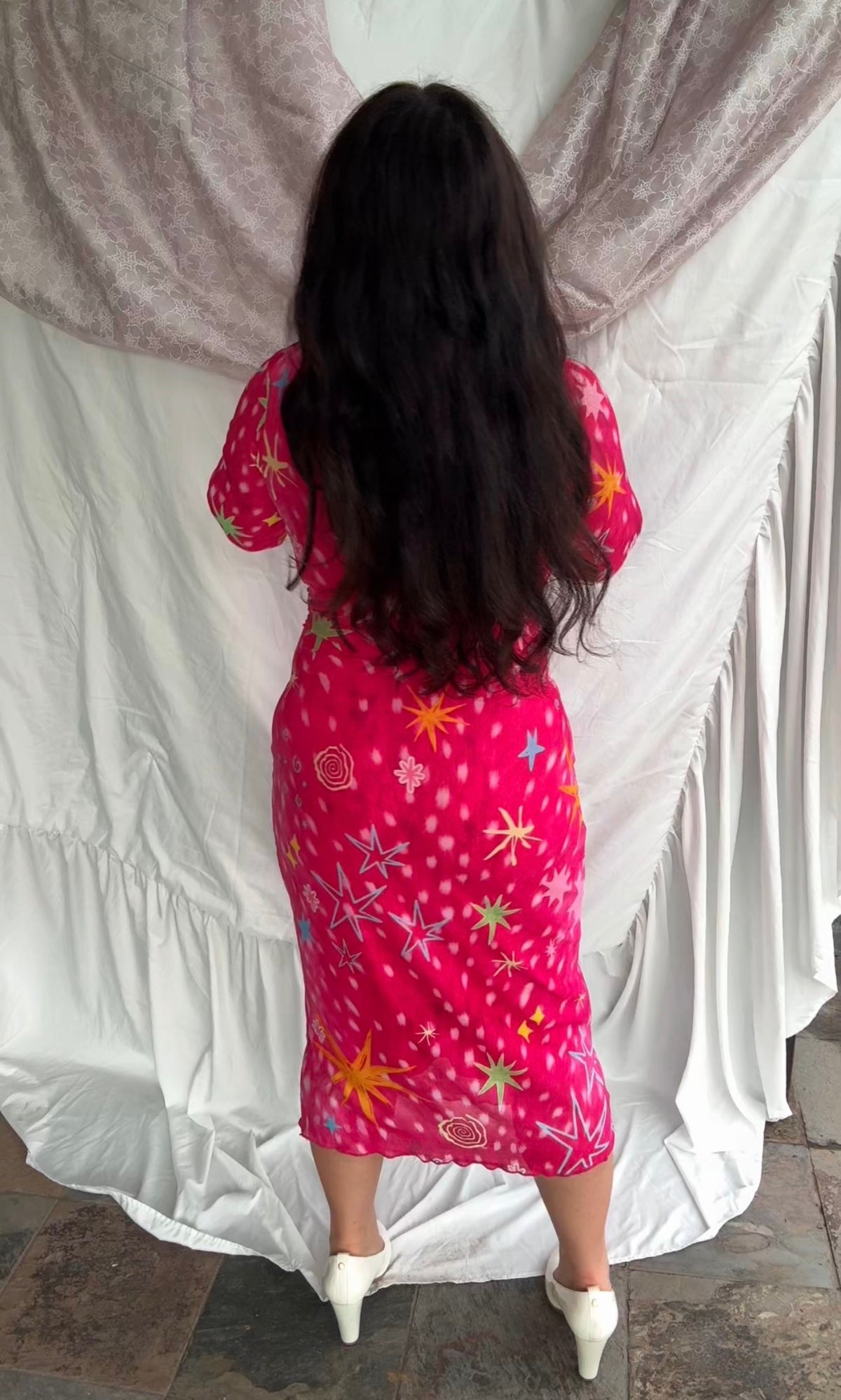 LOVE WORLD’s Deer Stars hot pink mesh midi dress with multicolored stars, spirals, and blue flame accents on long sleeves