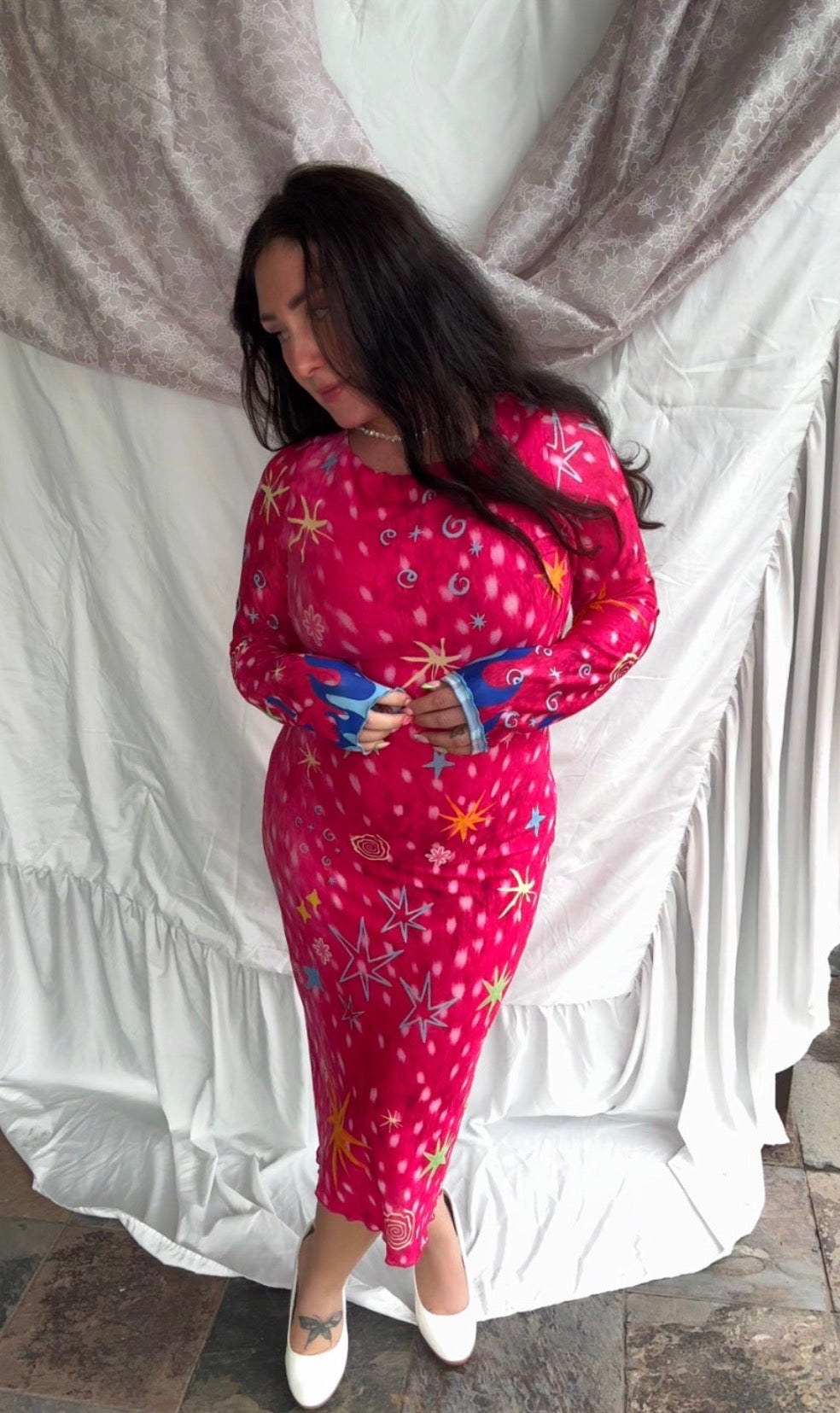 LOVE WORLD’s Deer Stars hot pink mesh midi dress with multicolored stars, spirals, and blue flame accents on long sleeves