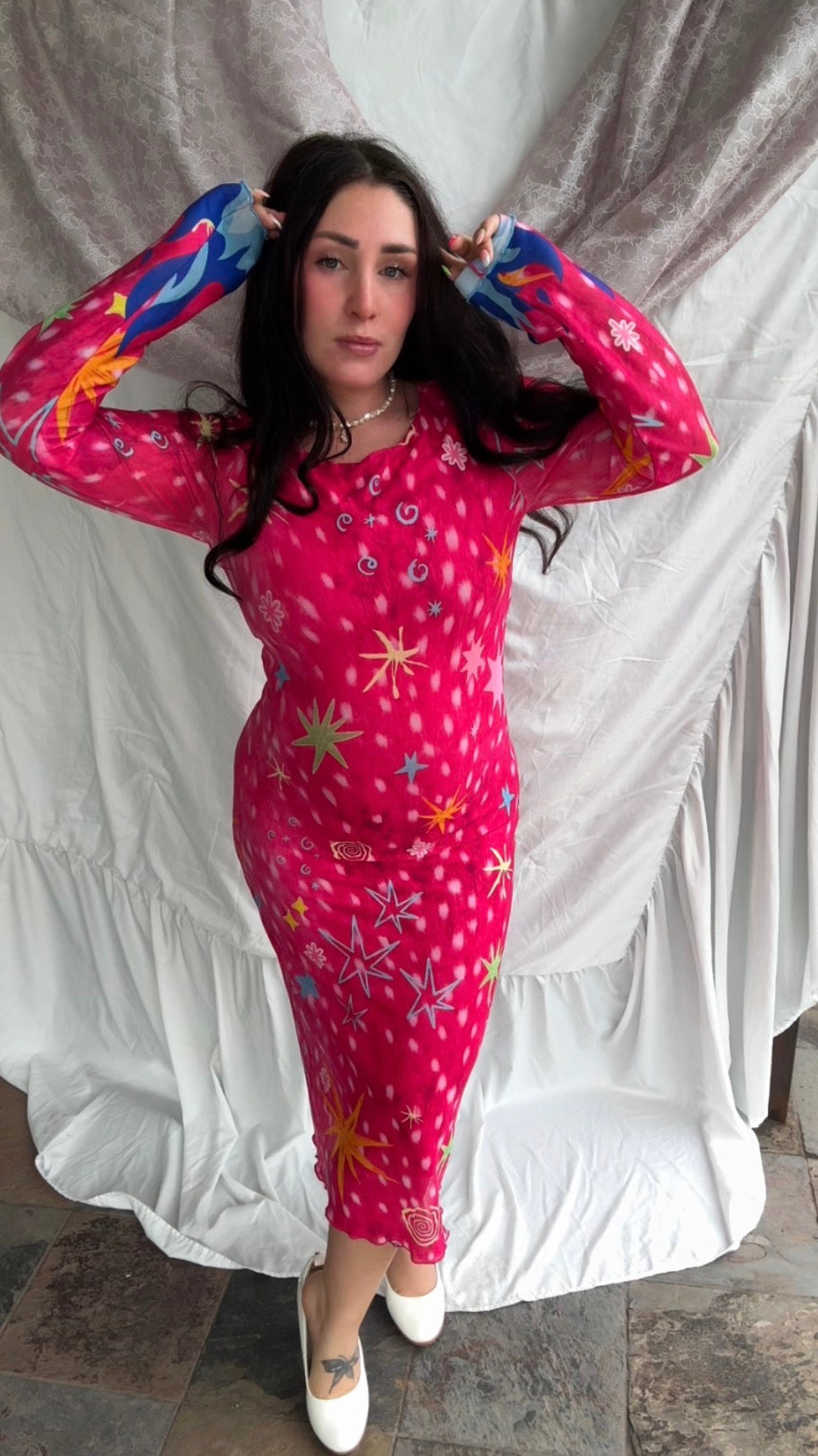 LOVE WORLD’s Deer Stars hot pink mesh midi dress with multicolored stars, spirals, and blue flame accents on long sleeves