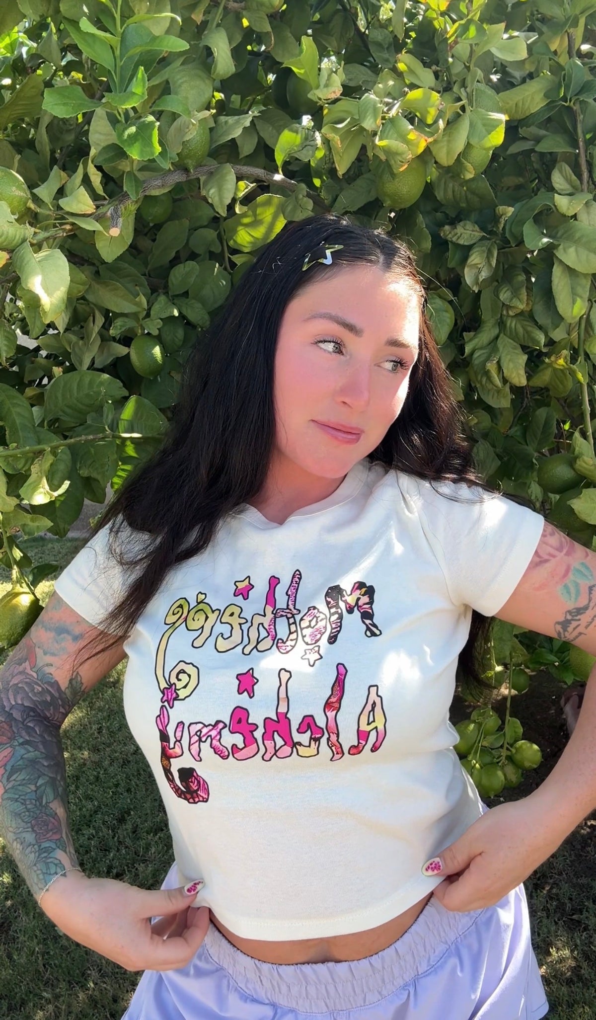 Woman wearing the LOVE WORLD Mothers Alchemy fitted crop tee in natural blend, hands on hips